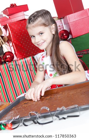Cute little girl making Christmas cookies at a table