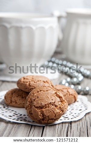 Cup of coffee or tea and almond cookies served on old wooden table