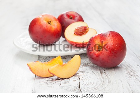 Juicy fresh peaches on a white wooden background