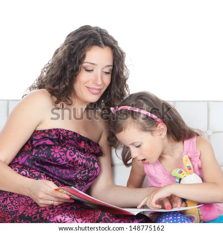Beautiful happy mother and little 5 years old girl reading a book on white