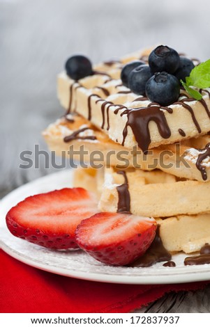 Delicious Belgian waffle with fresh berries and chocolate for breakfast