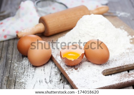 Baking ingredients - flour, eggs and rolling pin on a table