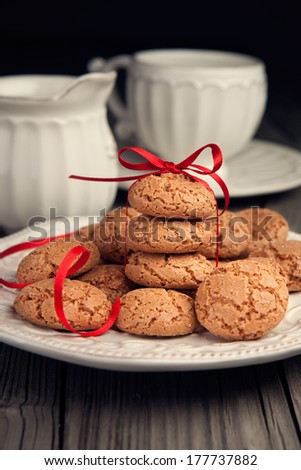 Almond cookies and cup of tea served on old wooden table