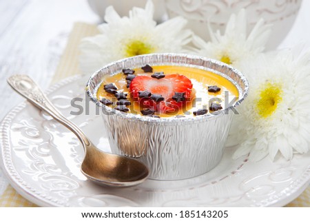 Italian dessert - panna cotta with chocolate and strawberry on white wooden table