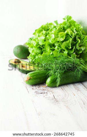 Fresh green vegetables on white wooden background, selective focus