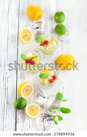 Fresh summer lemonade with mint and berries on a white wooden background, top view