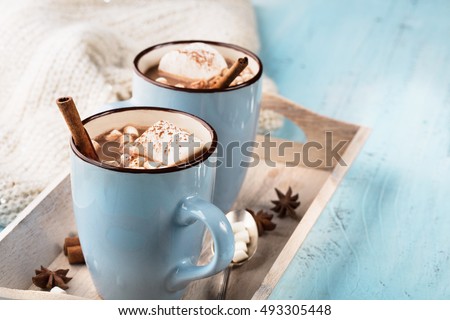 Blue Cup of hot Chocolate drink with Marshmallows and cinnamon on blue wooden background. Winter time. Holiday concept, Selective focus