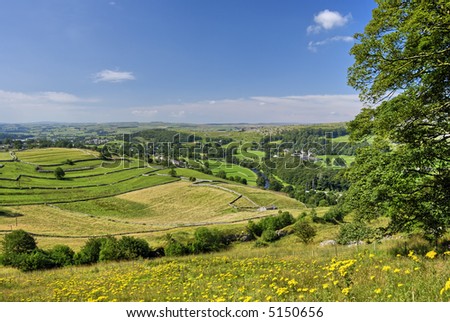 A view of the Ribble valley from the flower meadows of Lancliffe Scar. The river Ribble can be seen flowing past fields seperated by dry stone walls