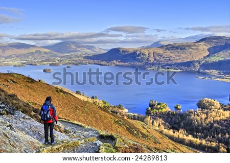 A Female hiker descending the path from Cat bells with Derwent Water in the background