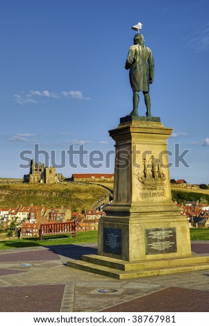 Statue of Captain James Cook with Whitby town ruined abbey in background, North Yorkshire, England.