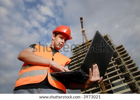 Construction supervisor in safety helmet and reflex vest with notebook in front of construction site.