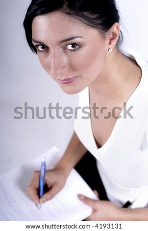 Picture of woman handwriting notes with blue pen.