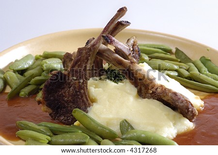 Picture of pork ribs with sauce, stewed vegetables and mashed potatoes.