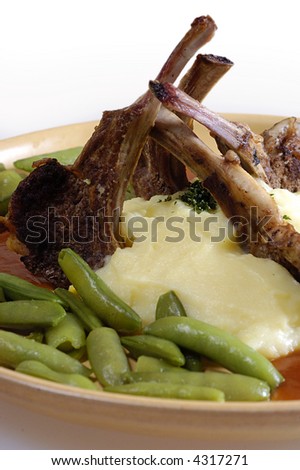Picture of pork ribs with sauce, stewed vegetables and mashed potatoes.