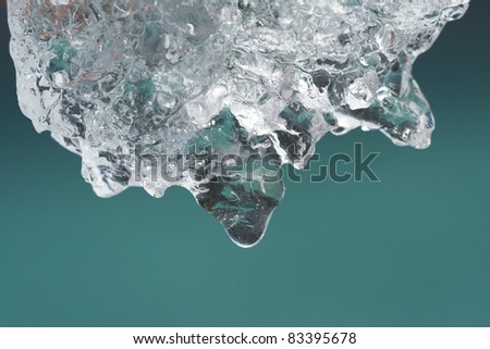 Melting ice from glacier with water drop over color of mountain lake. (Heating , clean drinking water concept)