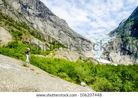 Two kids looking at glacier melting in glacier valley carved by the ice for thousands of years.