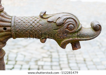 Old rusty water tap in the shape of an old gothic fantasy animal or dragons head.