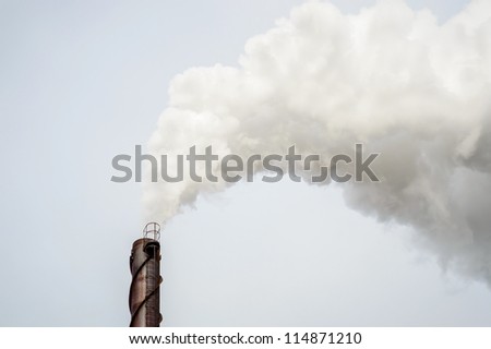 Smoke from metal chimney drifting in the wind
