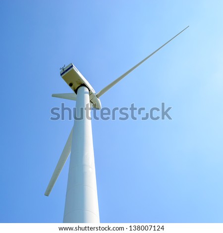 Wind turbine against blue sky. Wind power is the conversion of wind energy into a useful form of energy, such as using wind turbines to make electrical power.