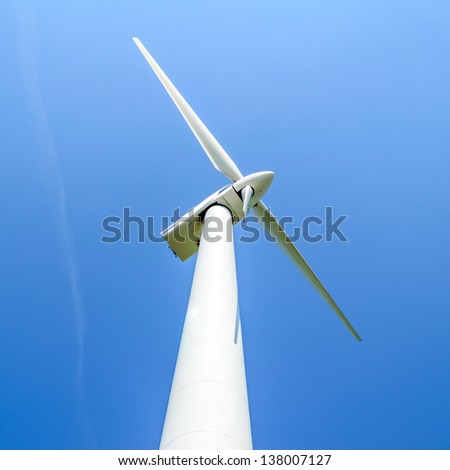 Wind turbine against blue sky. Wind power is the conversion of wind energy into a useful form of energy, such as using wind turbines to make electrical power. Here is one turbine seen from below.