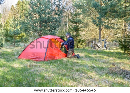 KALMAR, SWEDEN - APRIL 04, 2014: Man organizes Hilleberg tent for sleepover in Swedish nature in early spring.