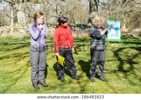KALMAR, SWEDEN - APRIL 05, 2014: Three female nature guides showing map on guide tour