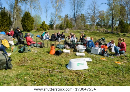 NYBRO, SWEDEN - APRIL 23, 2014: Group of people taking a brake during freshwater excursion.