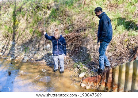 KALMAR, SWEDEN - APRIL 23, 2014: Person examining waterspeed in creek to establish water flow.