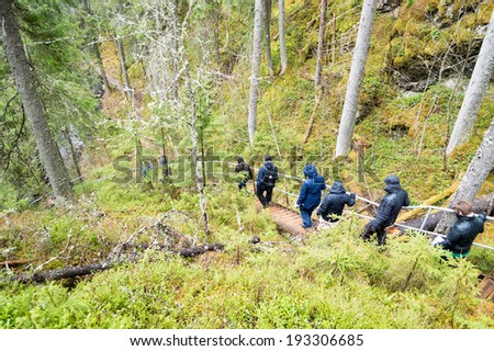 DALARNA, SWEDEN - MAY 07, 2014: People visiting old meteorite impact crater deep in the woods. Geological formations and steep edges. Meteorite hit about 377 miljon years ago and created Siljan.