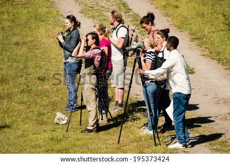 OLAND, SWEDEN - MAY 26, 2014: A group of bird watchers looking for birds beside gravel road.