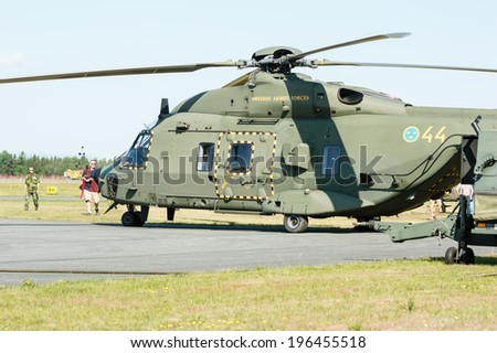 KALLINGE, SWEDEN - JUNE 01, 2014: Swedish Air Force air show 2014 at F 17 Wing. Green  NHIndustries; NH90, hkp 14, on ground. People looking at it.