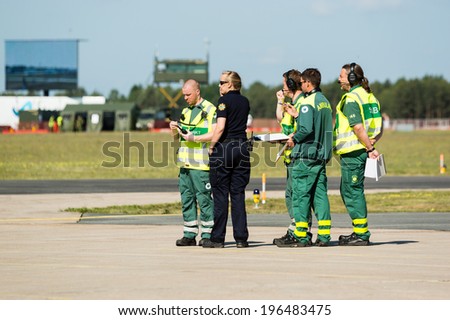 KALLINGE, SWEDEN - JUNE 01, 2014: Swedish Air Force air show 2014 at F 17 Wing. Rescue and paramedic personnel in strategic talk.