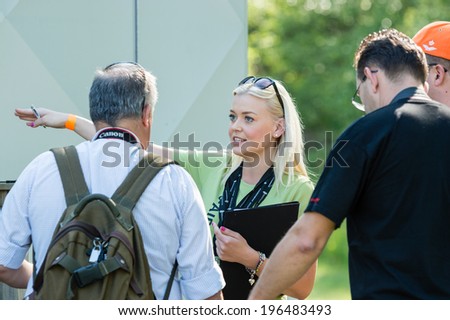 KALLINGE, SWEDEN - JUNE 01, 2014: Swedish Air Force air show 2014 at F 17 Wing. Young woman instructing persons on where to go.