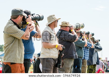 KALLINGE, SWEDEN - JUNE 01, 2014: Swedish Air Force air show 2014 at F 17 Wing. Aviation photographers on parade. Pointing cameras at sky.