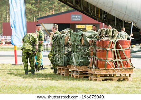 KALLINGE, SWEDEN - JUNE 01, 2014: Swedish Air Force air show 2014 at F 17 Wing. Cargo ready to be shipped. Nets, pallets and personnel.
