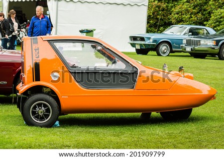 RONNEBY, SWEDEN - JUNE 28, 2014: Nostalgia Festival, classic cars, motorcycles, fashion and entertainment. Three wheeled Bond Bug 700es, orange.