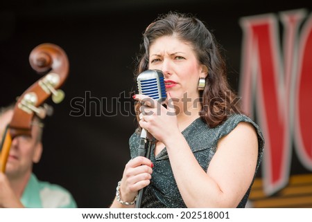 RONNEBY, SWEDEN - JUNE 28, 2014: Nostalgia Festival, classic cars, motorcycles, fashion and entertainment. Therese Moller as Cherry Tess singing.