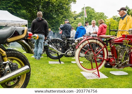 RONNEBY, SWEDEN - JUNE 28, 2014: Nostalgia Festival with classic cars and motorcycles as main attractions. Old motorcycles on display with crowd looking.