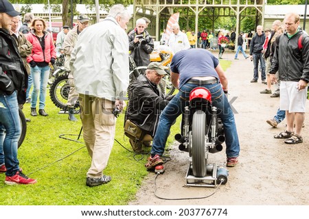 RONNEBY, SWEDEN - JUNE 28, 2014: Nostalgia Festival with classic cars and motorcycles as main attractions. Person trying to start old motorcycle on starter.