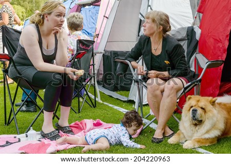 RONNEBY, SWEDEN - JULY 05, 2014: Blekinge Kennelklubb international dog show. Two women talking with baby and dag on ground.