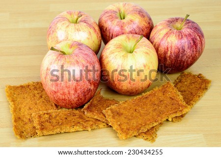 Natural fresh apples together with tasty dehydrated apple leather on wooden table. Dry fruit leather is a perfect bush tucker or bush food when on a hike.