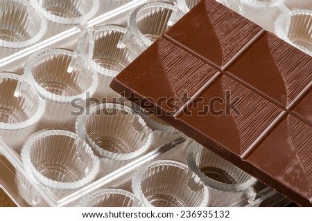 Plastic chocolate praline mold with dark rich chocolate on top.