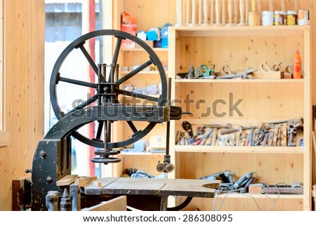 BJORKERYD, SWEDEN - JUNE 07, 2015: Old band saw with tools on a shelf in background. Old patent sign and manufacturer sign on machine.