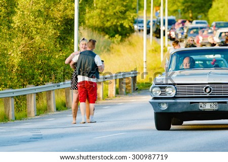 RONNEBY, SWEDEN - JUNE 26, 2015: Car break down and cause some chaos on the street during a road cruise for veteran cars. Drunk passengers behave unsafe and venture into street.