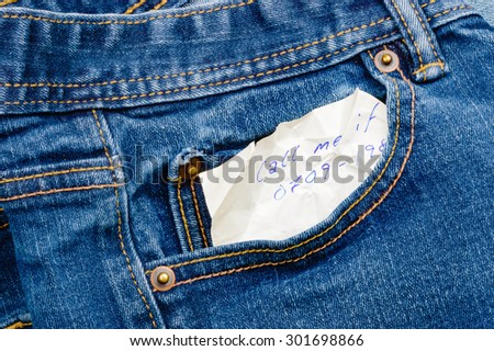 Secretive handwritten message in denim pocket, from someone that wants a call about something. Perhaps the note was found before laundry and suggests a secret lover. Note is wrinkled and ink is blue.