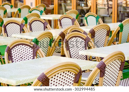 Empty chairs from outdoor diner before the customers arrive. Woven material in purple and green on chairs.