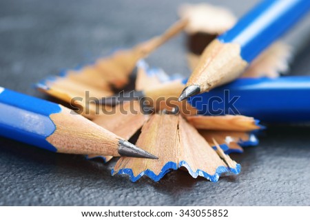 Blue graphite pencils with shavings on dark stone surface. Close up of this universal and powerful tool for artists, writers and students. Also a symbol of intellect, learning and literacy.