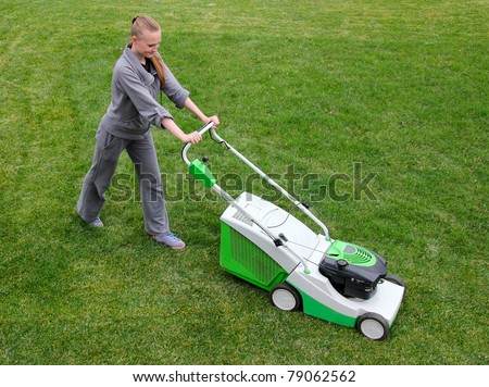 Beautiful girl cuts the lawn