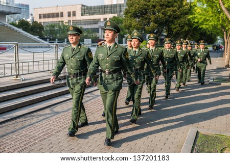 SHANGHAI, CHINA - APR 7, 2013: chinese red army soldiers marching in the street at the city of Shanghai in China on april 7th, 2013
