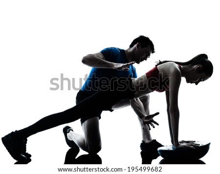 personal trainer man coach and woman exercising abdominals push ups on bosu silhouette studio isolated on white background